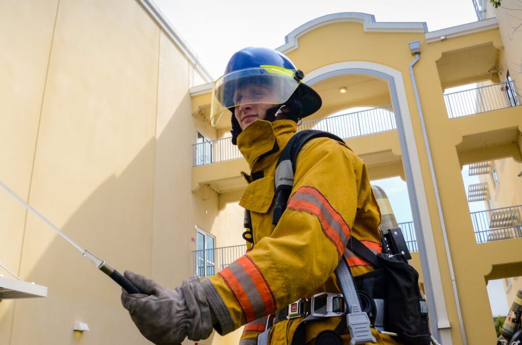 A firefighter in full protective gear operates outdoors in an urban setting, ensuring safety and protection.